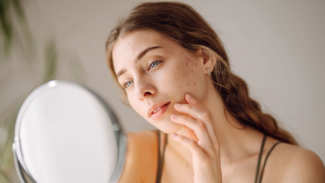 Woman examining her skin in mirror.