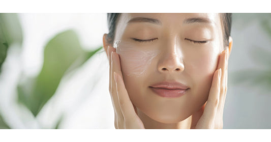 Woman applying moisturizer to her face.